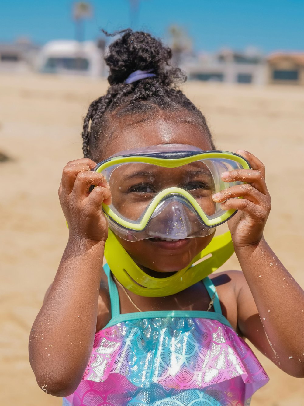 close up picture of african american little child with a pair of yellow goggle on her face